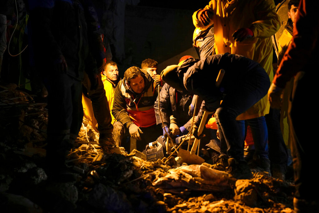 Emergency teams search in the rubble for survivors in a destroyed building in Adana, Turkey, Monday, Feb. 6, 2023. (AP Photo/Khalil Hamra)