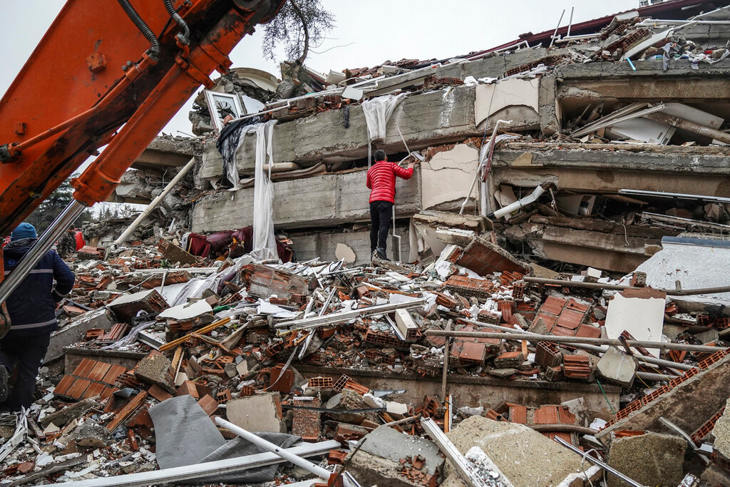 A man searches for survivors in the rubble of a destroyed building in Gaziantep, Turkey, Monday, Feb. 6, 2023. (AP Photo/Mustafa Karali)