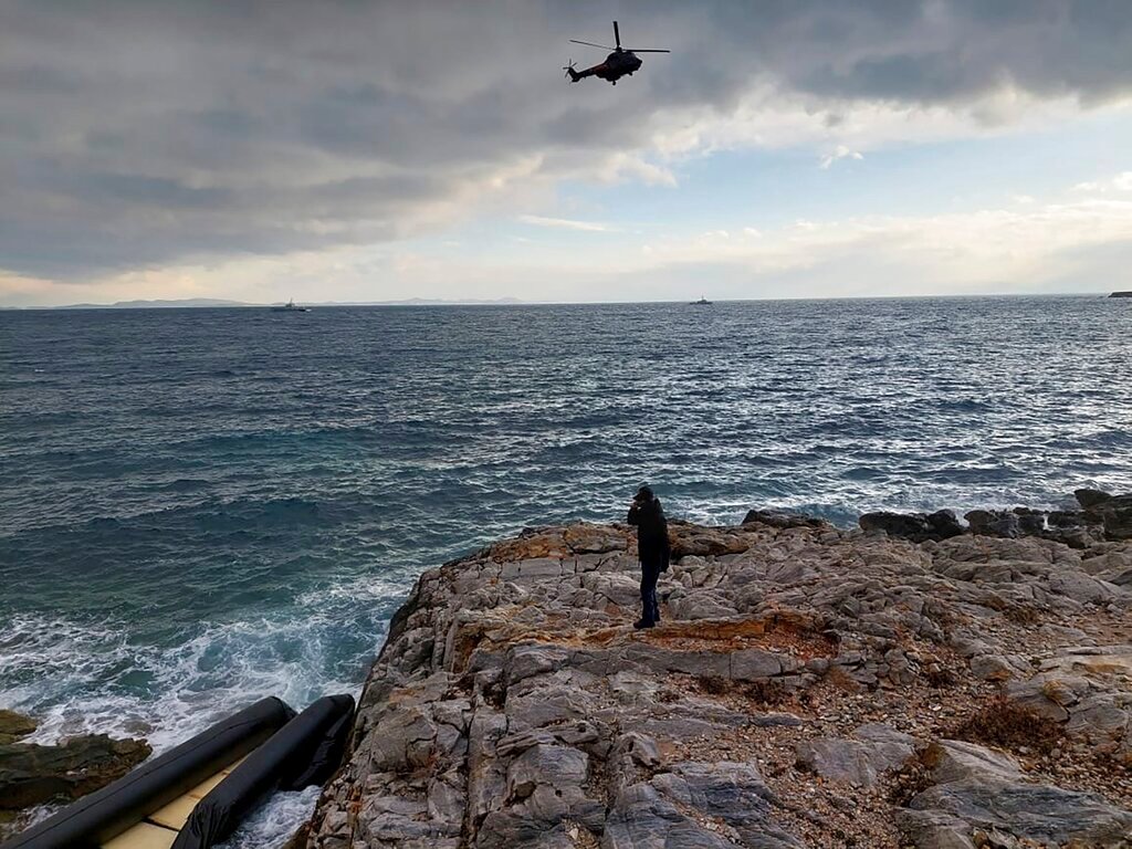 A helicopter searches over the Aegean Sea near the northwestern island of Lesbos, Greece, Tuesday, Feb. 7, 2023. Three migrants died and 16 were rescued off the Greek island of Lesbos Tuesday after a dinghy transporting them from the nearby coast of Turkey hit rocks in high winds, authorities said. (Greek Coast Guard via AP)