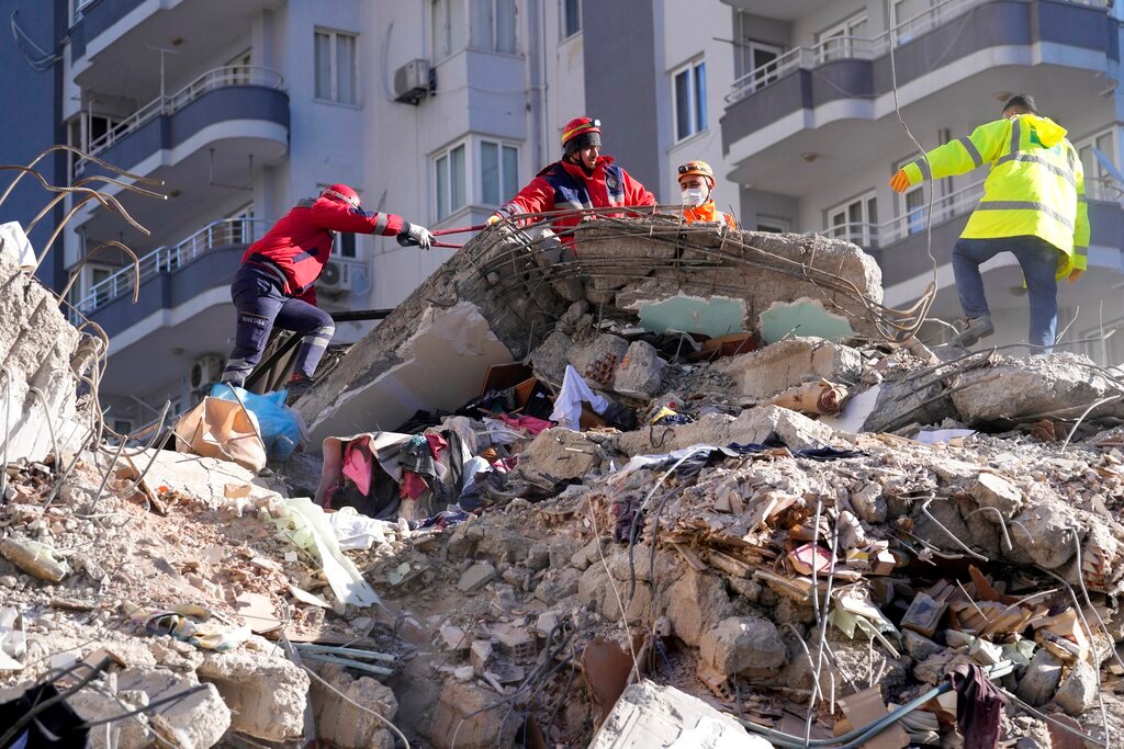 Emergency teams search for people in the rubble in a destroyed building in Adana, southern Turkey, Tuesday, Feb. 7, 2023. (AP Photo/Hussein Malla)