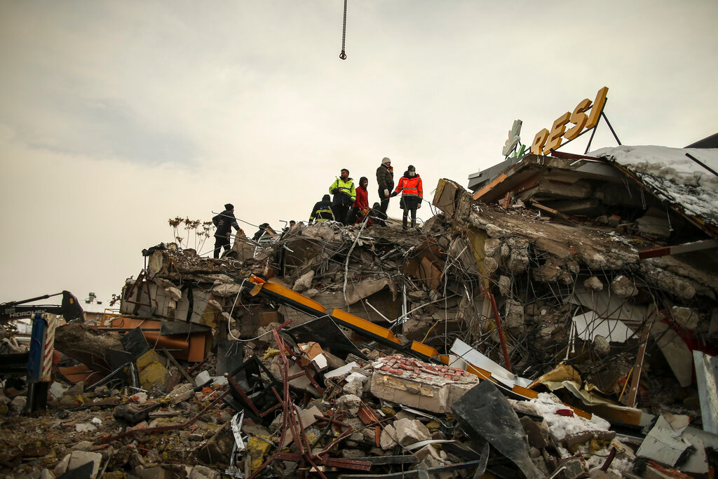 Rescue workers search for survivors in a collapsed building in Malatya, Turkey, Tuesday, Feb. 7, 2023. (AP Photo/Emrah Gurel)