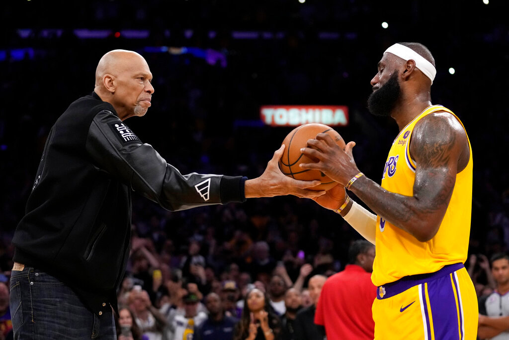 Kareem Abdul-Jabbar, left, hands the ball to Los Angeles Lakers forward LeBron James after James passed Abdul-Jabbar to become the NBA's all-time leading scorer during the second half against the Oklahoma City Thunder Tuesday, Feb. 7, 2023, in Los Angeles. (AP Photo/Ashley Landis)