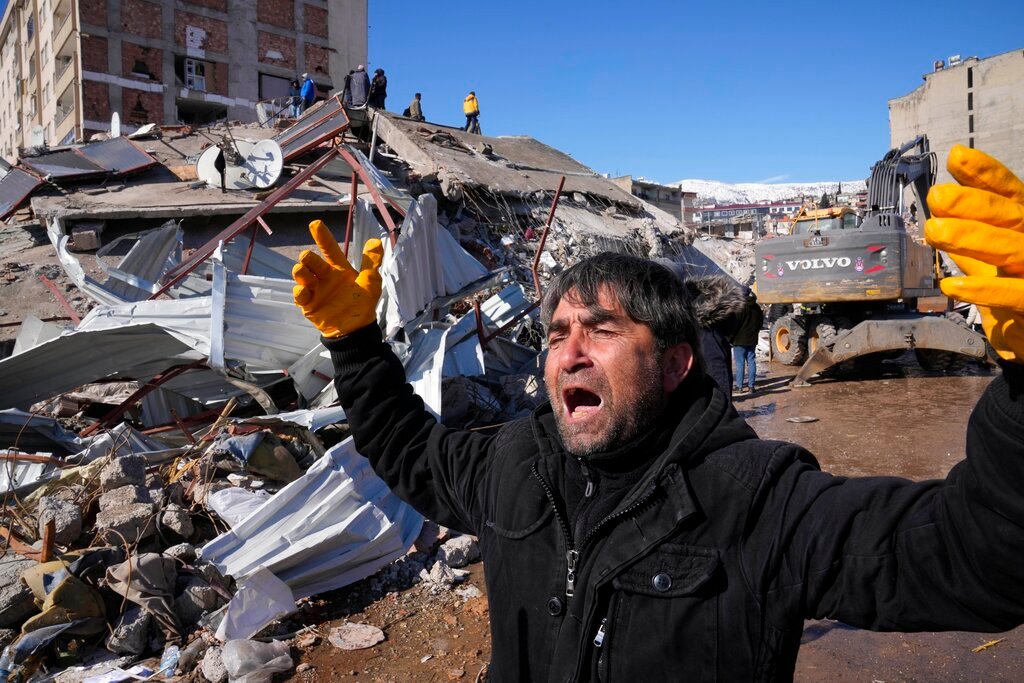 A man reacts after rescue teams found his father dead under a collapsed building, in Kahramanmaras, southern Turkey, Wednesday, Feb. 8, 2023. (AP Photo/Hussein Malla)