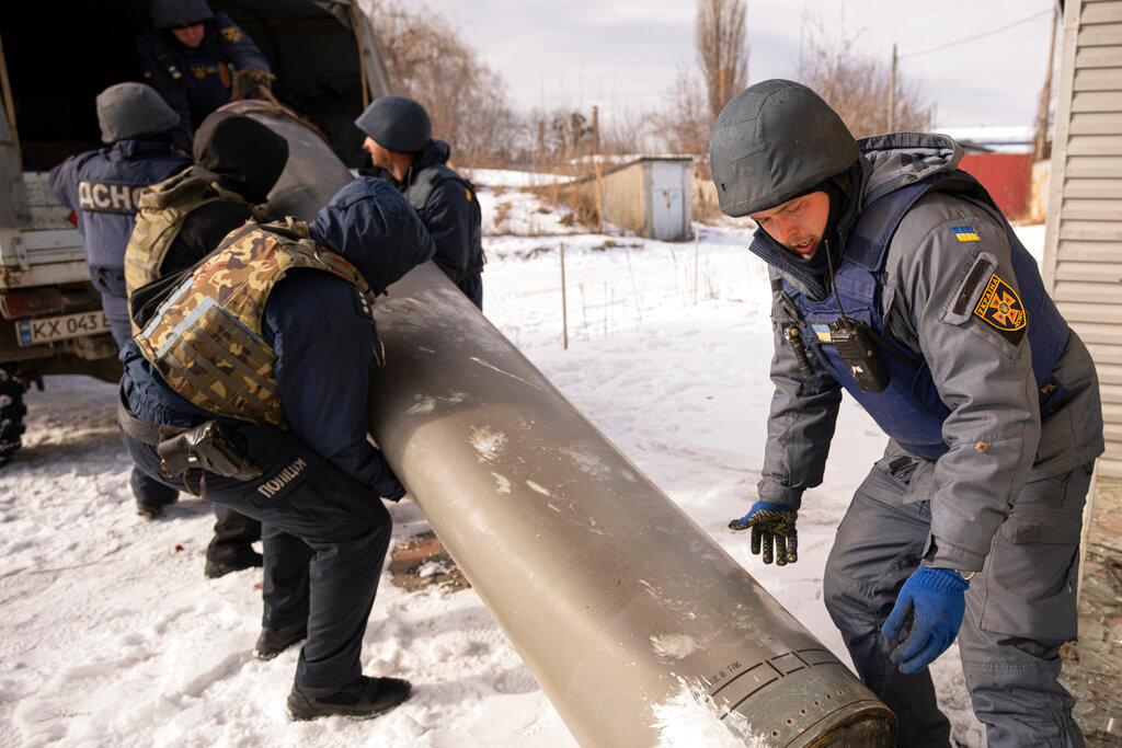 Ukrainian emergency services employees push the remains of an S-300 missile fired by Russian forces onto a truck in Kharkiv, Ukraine, Friday, Feb. 17, 2023. (AP Photo/Vadim Ghirda)