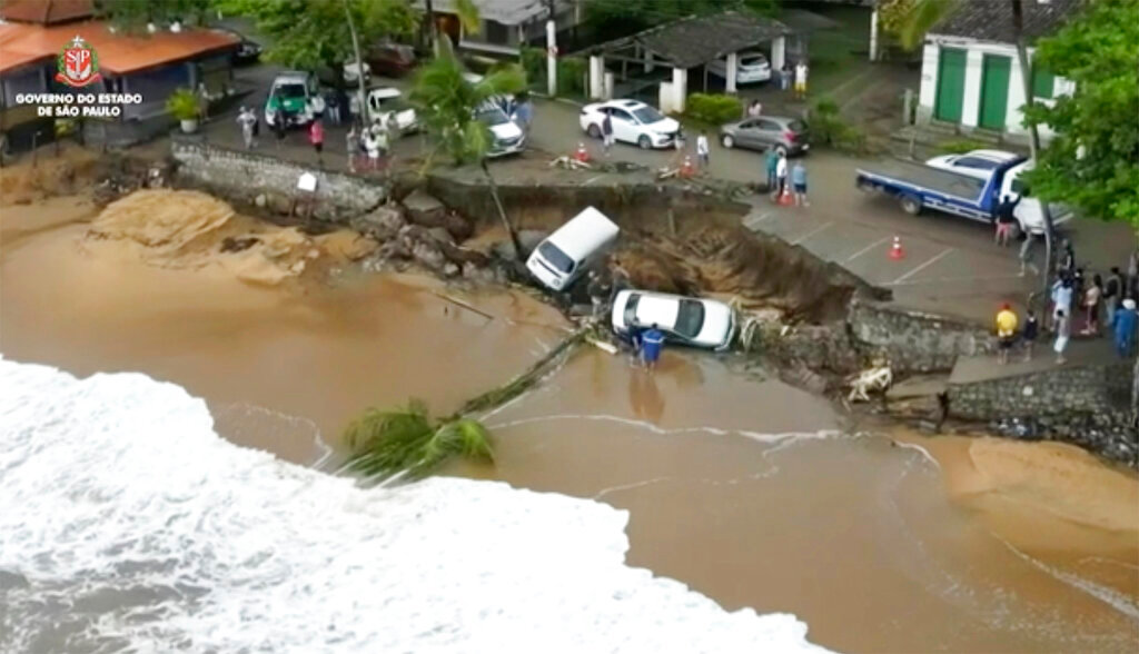 Vehicles lie in a collapsed parking area along the beach in Sao Sebastiao, east of Sao Paulo, Brazil, Sunday, Feb. 19, 2023, after it was damaged by a severe weather system that went through the area. (Sao Paulo Government via AP)