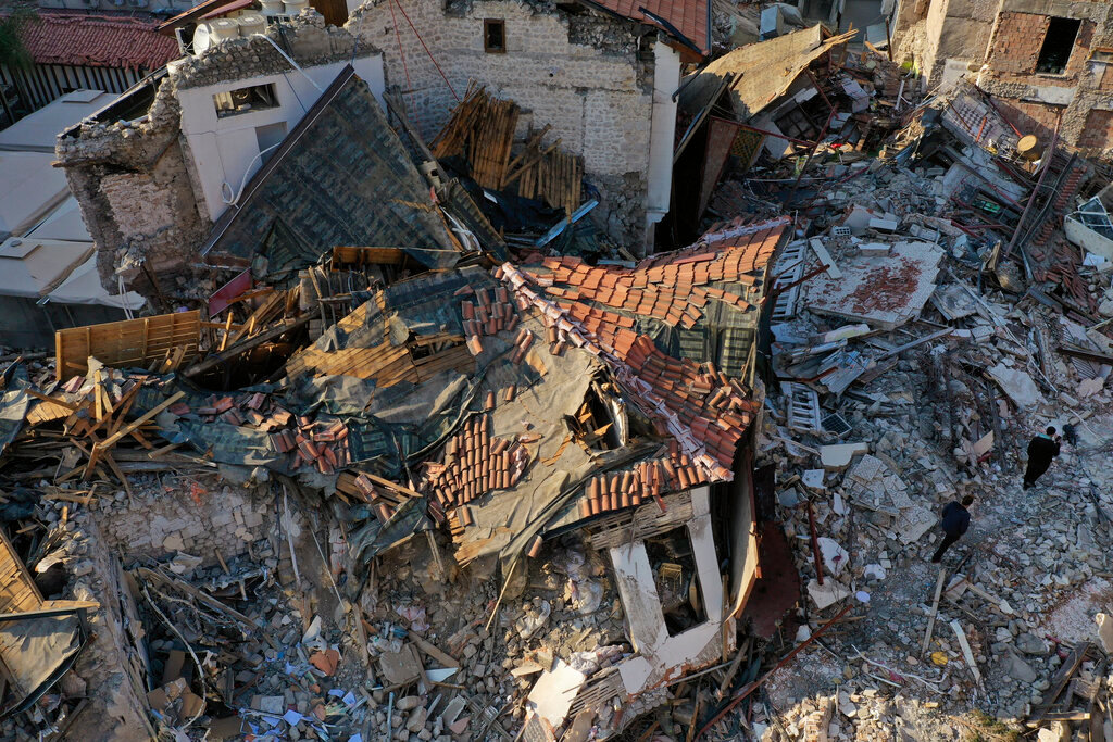 People walk on the debris of historic houses that were destroyed by a devastating earthquake, in the old city of Antakya, Turkey, Monday, Feb. 13, 2023. (AP Photo/Hussein Malla)