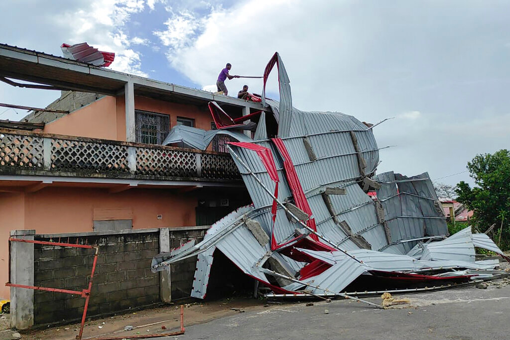 People work on a damaged building, in Mananjary district, Madagascar, Wednesday, Feb. 22, 2022, in the aftermath of cyclone Freddy. (AP Photo/Solofo Rasolofomanana)