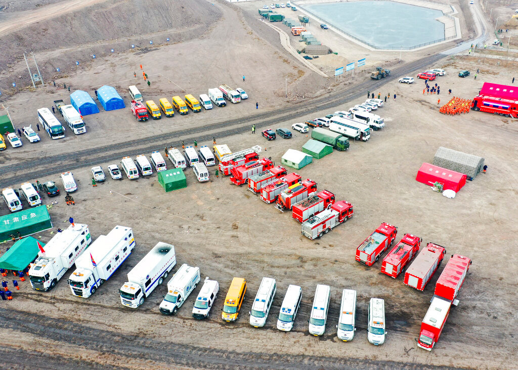Rescue vehicles are parked near the site of a collapsed open pit coal mine in Alxa League in northern China's Inner Mongolia Autonomous Region, Thursday, Feb. 23, 2023. (Lian Zhen/Xinhua via AP)