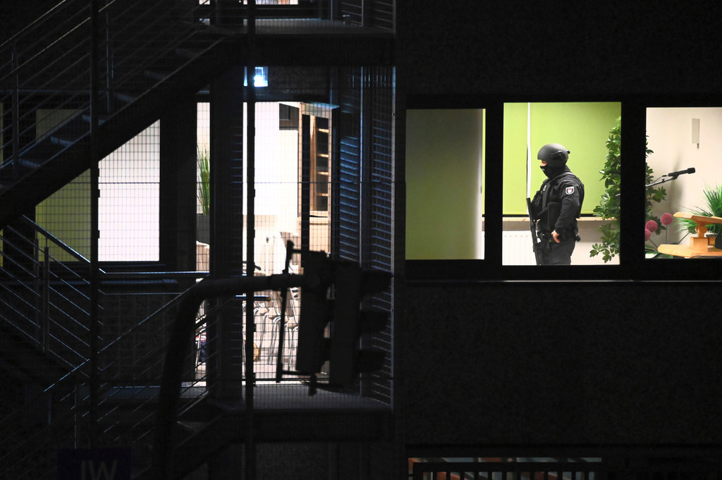 Police officers walk through a building used by Jehovah's Witnesses in the northern German city of Hamburg, Thursday, March 9, 2023. Shots were fired inside the building, with several people killed and wounded, police said. (Jonas Walzberg/dpa via AP)