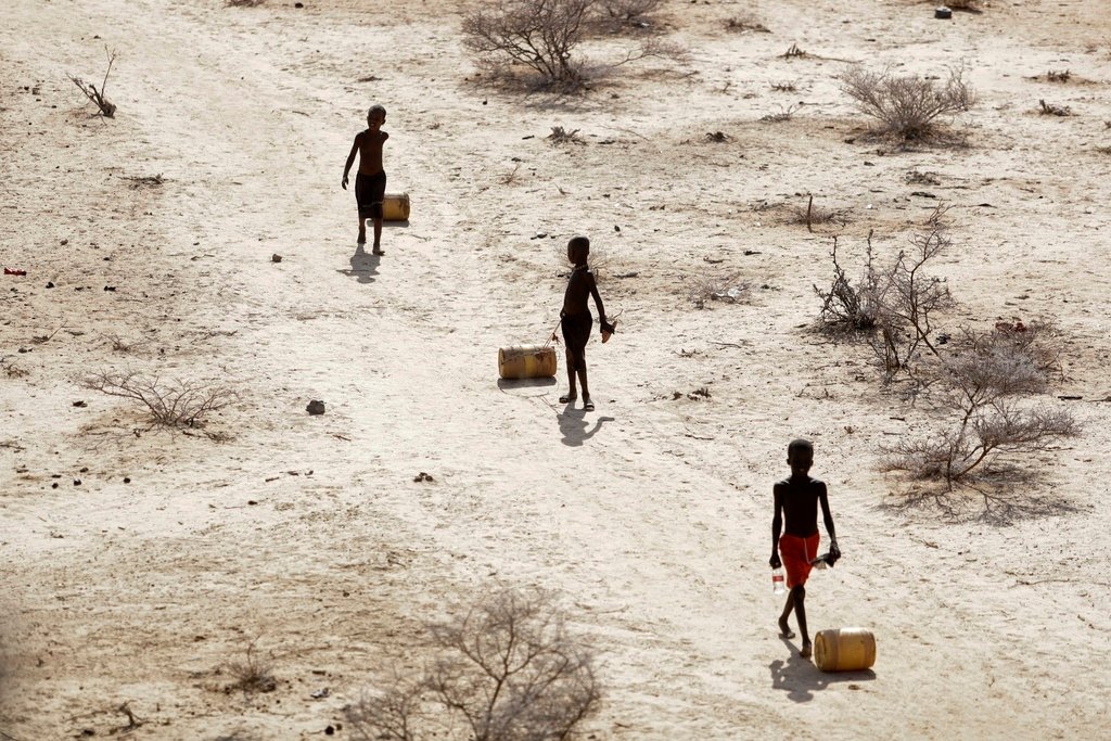 Young boys pull containers of water as they return to their huts from a well in the village of Ntabasi amid a drought in Samburu East, Kenya, Oct, 14, 2022. (AP Photo/Brian Inganga, File)