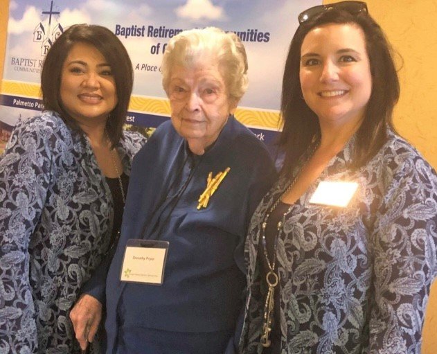 In this 2018 photo, Dorothy Pryor, center, poses for a photo with Sharalene Roper, right, and Shannon Watson at her retirement home.