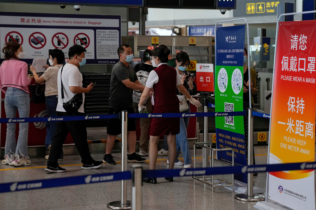 An airline worker asks travelers to declare their health information after checking in at the Beijing Capital International Airport in Beijing, Aug. 24, 2022. (AP Photo/Andy Wong, File)