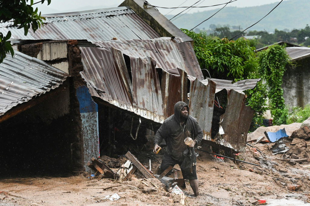 A man stands outside his damaged home in Blantyre, Malawi, Monday, March 13, 2023. (AP Photo/Thoko Chikondi)