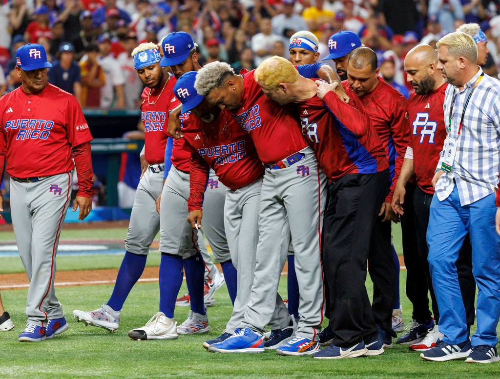 Puerto Rico pitcher Edwin Diaz (39) is helped by team pitching coach Ricky Bones and medical staff after a World Baseball Classic game against the Dominican Republic, Wednesday, March 15, 2023, in Miami. (David Santiago/Miami Herald via AP)