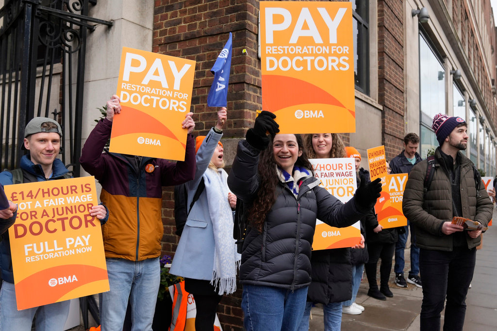Junior doctors hold placards on a picket line outside St Mary's Hospital in London, Tuesday, March 14, 2023. (AP Photo/Alastair Grant)