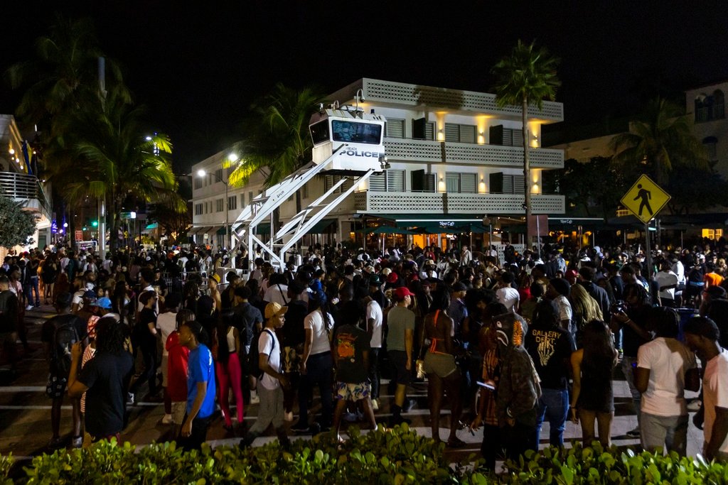 Crowds gather at Ocean Drive and 8th during spring break on Saturday, March 18, 2023, in Miami Beach, Fla. Miami Beach officials imposed a curfew beginning Sunday night, March 19, after two fatal shootings and rowdy, chaotic crowds that police have had difficulty controlling. (D.A. Varela/Miami Herald via AP)