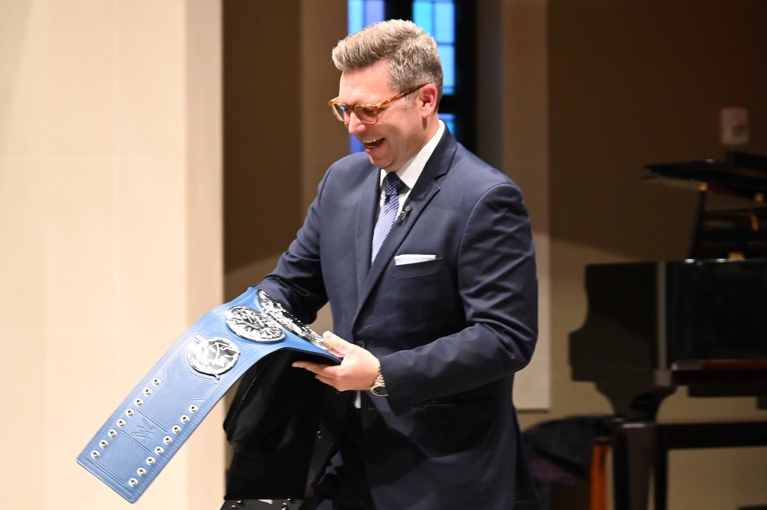 Brent Leatherwood reacts to a WWE championship belt given to him by SBC First Vice President Victor Chayasirisobhon at an installation service on Monday, March 20, 2023. (Index/Roger Alford)