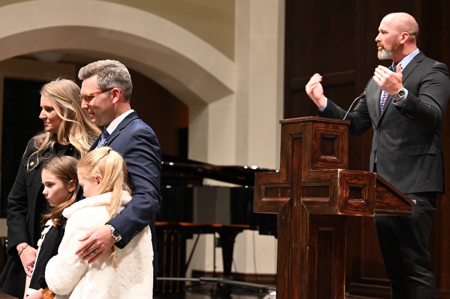 Brent Leatherwood stands with his wife and children at an installation service as his pastor, Aaron Bryant, calls for attendees to pray on Monday, March 20, 2023. (Index/Roger Alford)