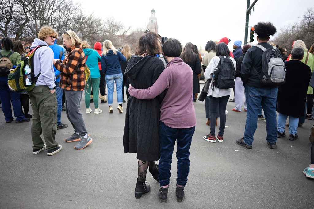 Isabella DeJoseph, 15, center left, is embraced by her mother Alana as they leave East High School after a school shooting, Wednesday, March 22, 2023, in Denver. Two school administrators were shot at the high school Wednesday morning after a handgun was found on a student subjected to daily searches, authorities said. (Hyoung Chang/The Denver Post via AP)
