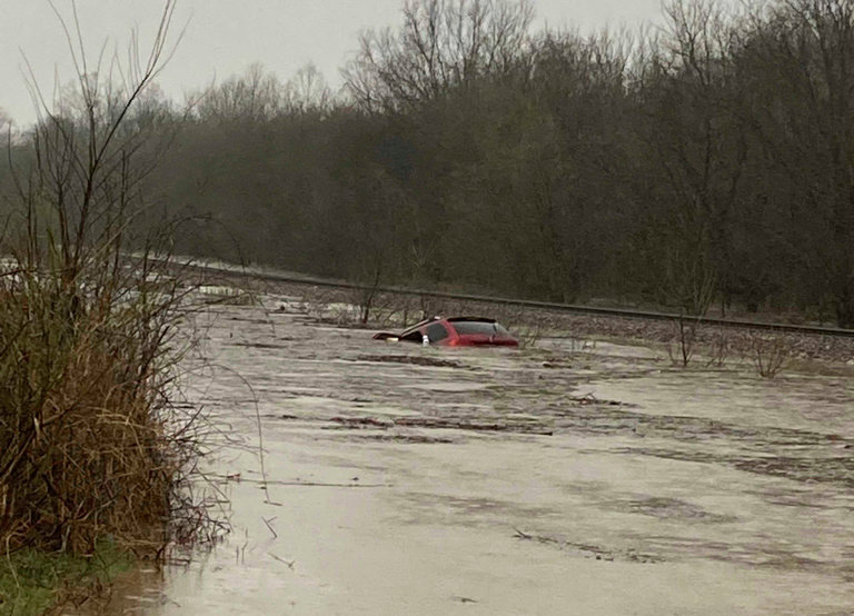 A red SUV is seen submerged in floodwater on Old Ritchey Road in Granby, Mo., early Friday, March 24, 2023. Layton Hoyer rescued an elderly woman from the car. (Layton Hoyer via AP)