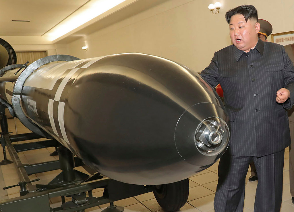 North Korean leader Kim Jong Un stands beside what appears to be a warhead designed to be mounted on missiles or rockets, March 27, 2023, in an undisclosed location in North Korea. (Korean Central News Agency/Korea News Service via AP)