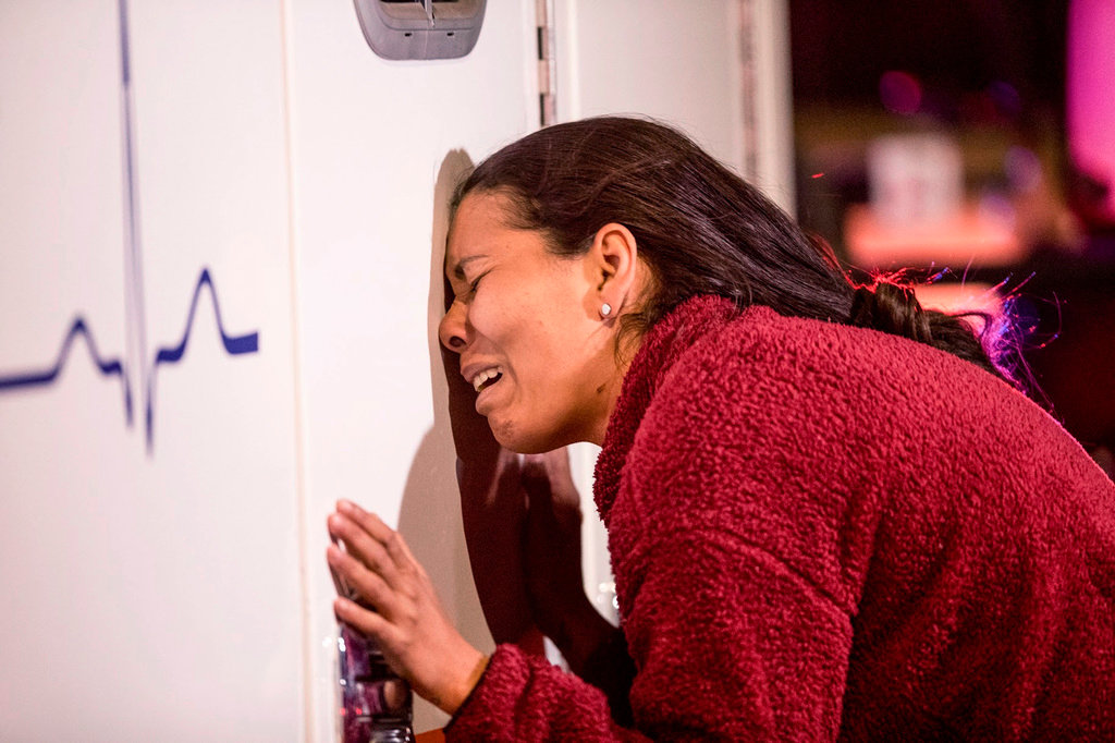 A migrant cries leaning on an ambulance as a person she knows is attended by medics after a fire broke out at the Mexican Immigration Detention center in Juarez on Monday, March, 27, 2023. (Omar Ornelas/The El Paso Times via AP)