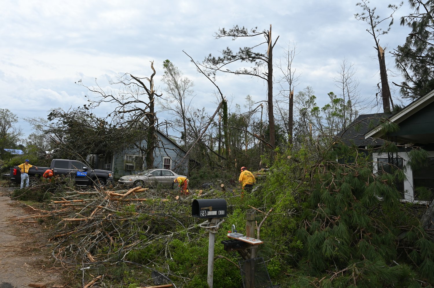 People navigate around debris left behind by a tornado that struck West Point, Ga., on Sunday. (Index/Roger Alford)