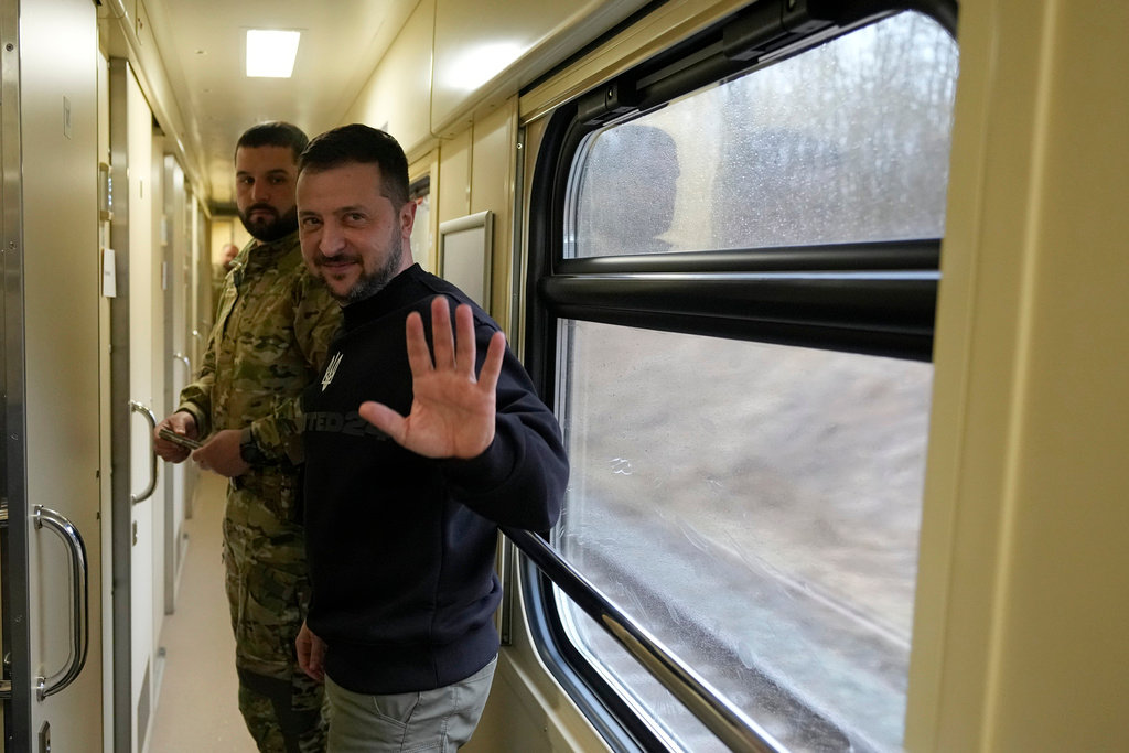 Ukrainian President Volodymyr Zelenskyy waves after an interview with The Associated Press on a train traveling from the Sumy region to Kyiv, Ukraine, Tuesday March 28, 2023. (AP Photo/Efrem Lukatsky)