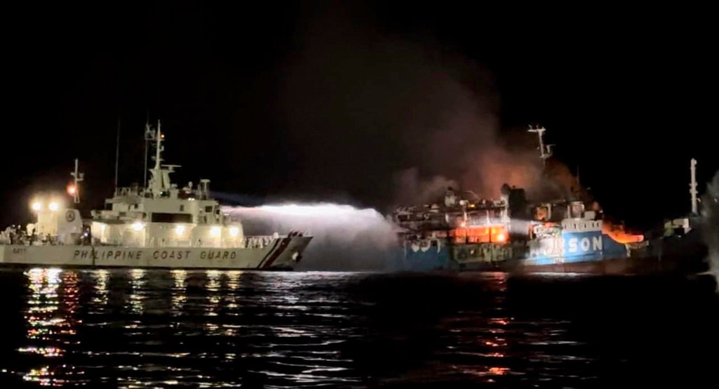 A Philippine Coast Guard ship tries to extinguish fire on the MV Lady Mary Joy at Basilan, southern Philippines early Thursday, March 30, 2023. (Philippine Coast Guard via AP)