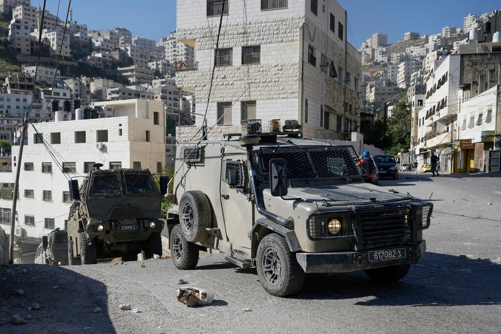 A convoy of Israeli military vehicles drives through the West Bank city of Nablus during a raid, Thursday, May 4, 2023. (AP Photo/Majdi Mohammed)