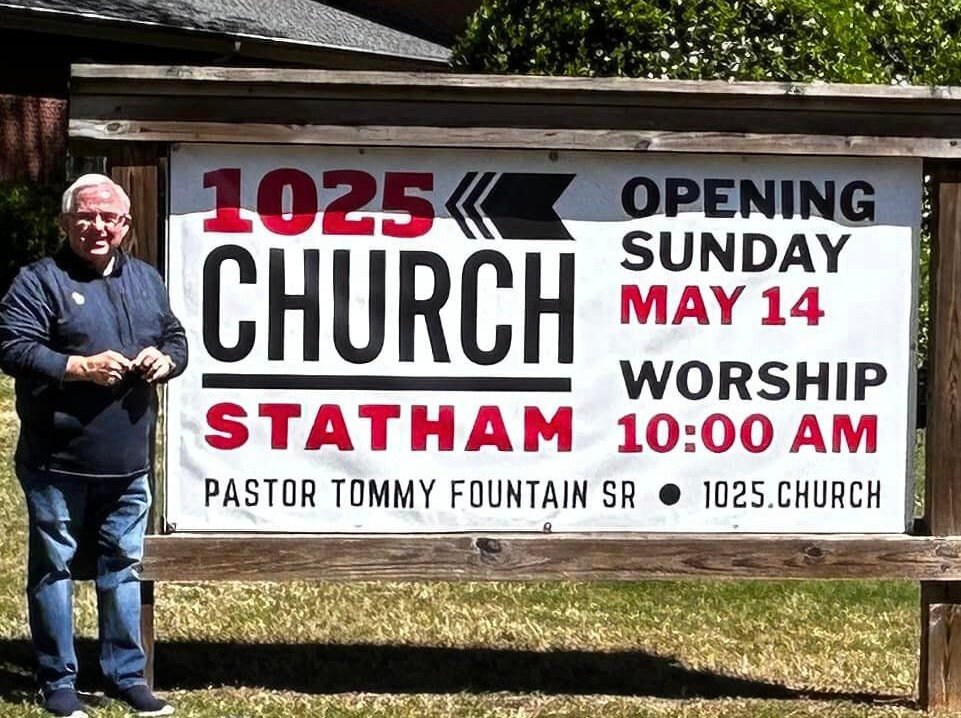 Pastor Tommy Fountain stands beside the sign announcing the launch date of 1025 Church Statham.