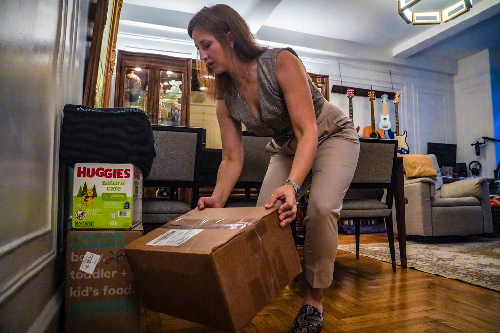 Jessica Ray moves deliveries from UPS, including baby food and diapers for her child, in her apartment on Friday, May 12, 2023, in New York. (AP Photo/Bebeto Matthews)