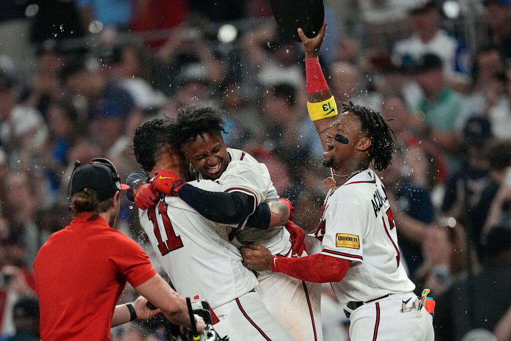Atlanta Braves' Ozzie Albies, center, celebrates with Orlando Arcia (11) and Ronald Acuna Jr. after driving in the winning run with a sacrifice fly against the Los Angeles Dodgers, Wednesday, May 24, 2023, in Atlanta. (AP Photo/John Bazemore)