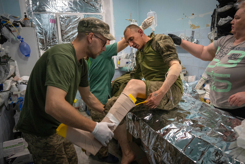 Military medics give first aid to wounded Ukrainian soldiers at a medical stabilisation point near Bakhmut, Donetsk region, Ukraine, Wednesday, May 24, 2023. (AP Photo/Efrem Lukatsky)