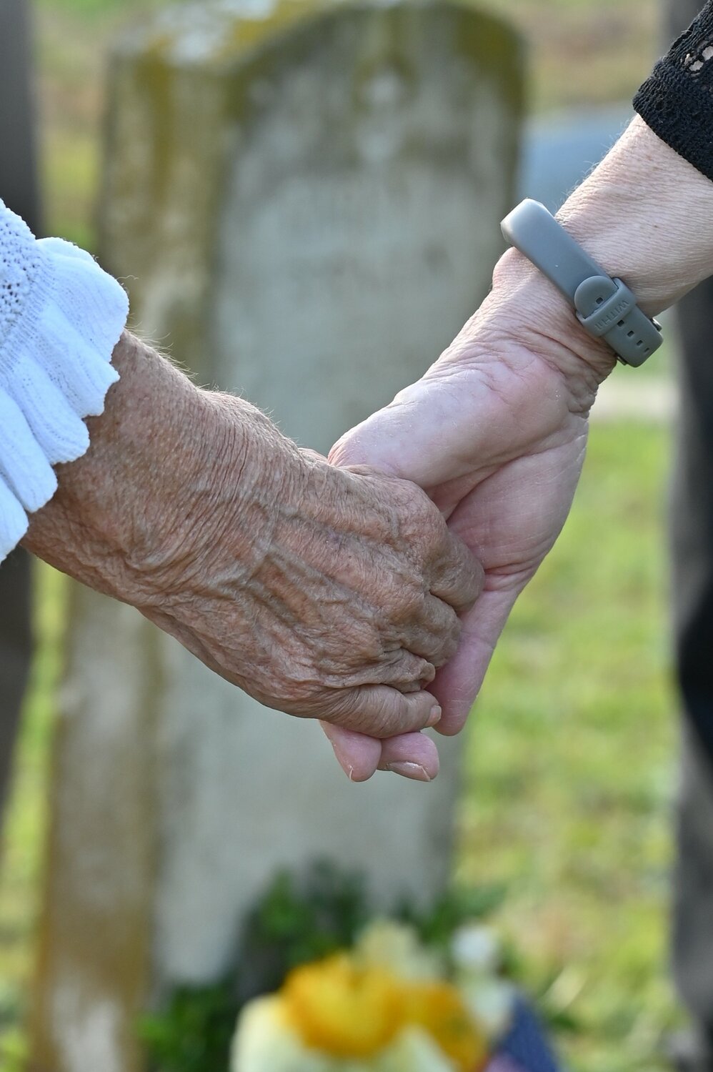 Family members hold hands as they honor Private Harry Spratlin at a cemetery near Hull, Georgia. (Index/Roger Alford)