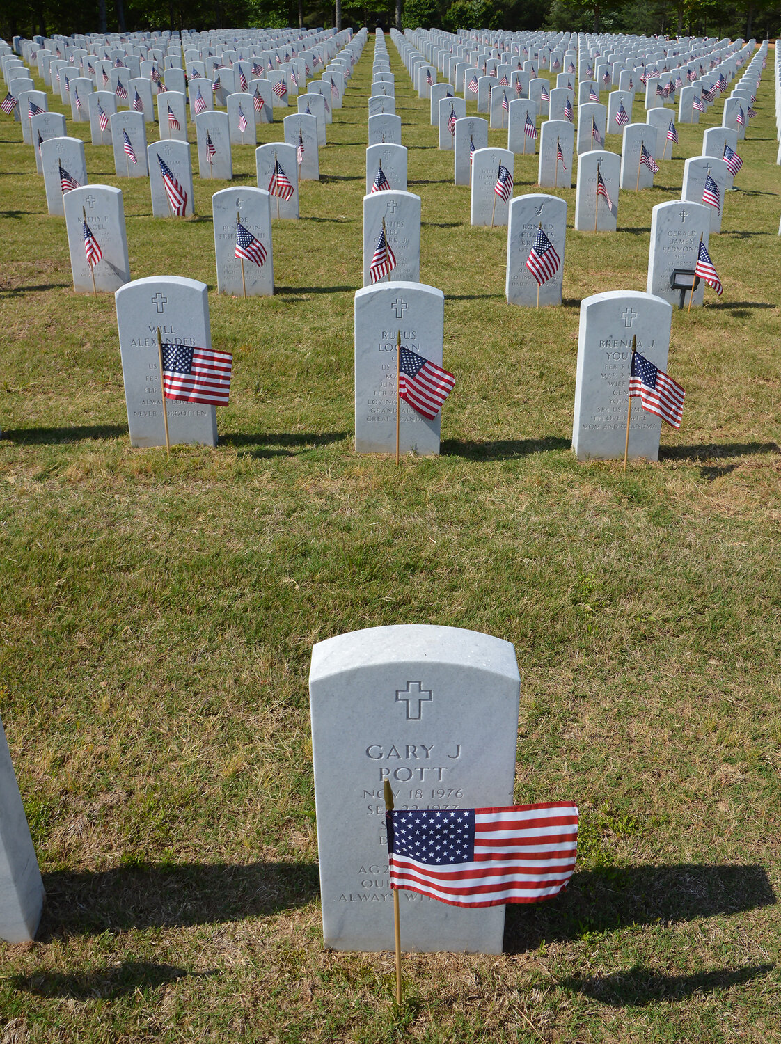Flags decorate graves at the Georgia National Cemetery in Canton, Ga., Saturday, May 27, 2023. (Index/Henry Durand)