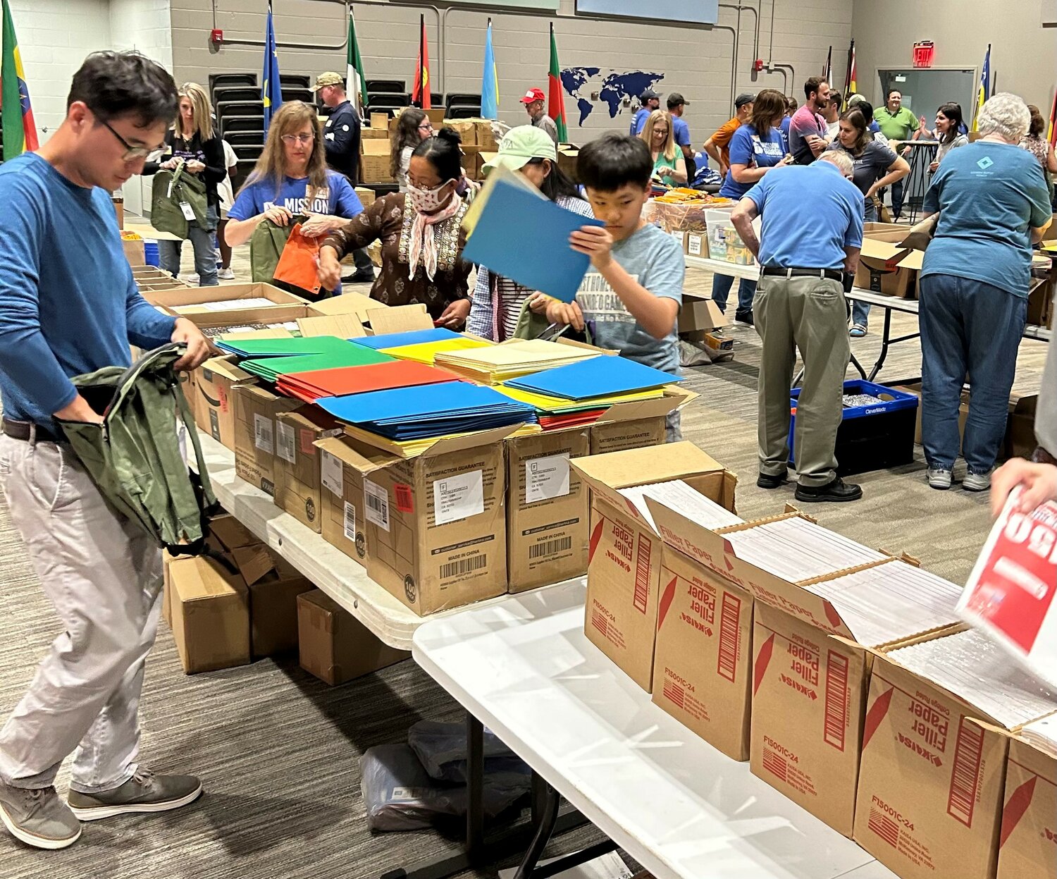 Volunteers fill backpacks with supplies for refugees at Clarkston International Bible Church in metro Atlanta on Saturday, May 27, 2023.