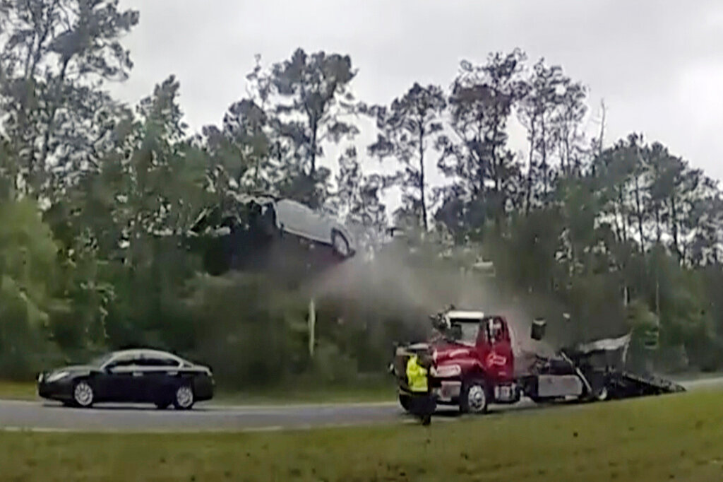 A vehicle goes airborne after driving up the ramp of a flatbed tow truck on a Georgia highway, Wednesday, May 24, 2023, in Lowndes County, Ga. (Lowndes County Sheriff's Office via AP)