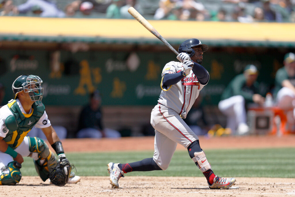 Atlanta Braves' Ozzie Albies hits a two-run home run in front of Oakland Athletics catcher Carlos Perez during the fifth inning  in Oakland, Calif., Thursday, May 31, 2023. (AP Photo/Jed Jacobsohn)