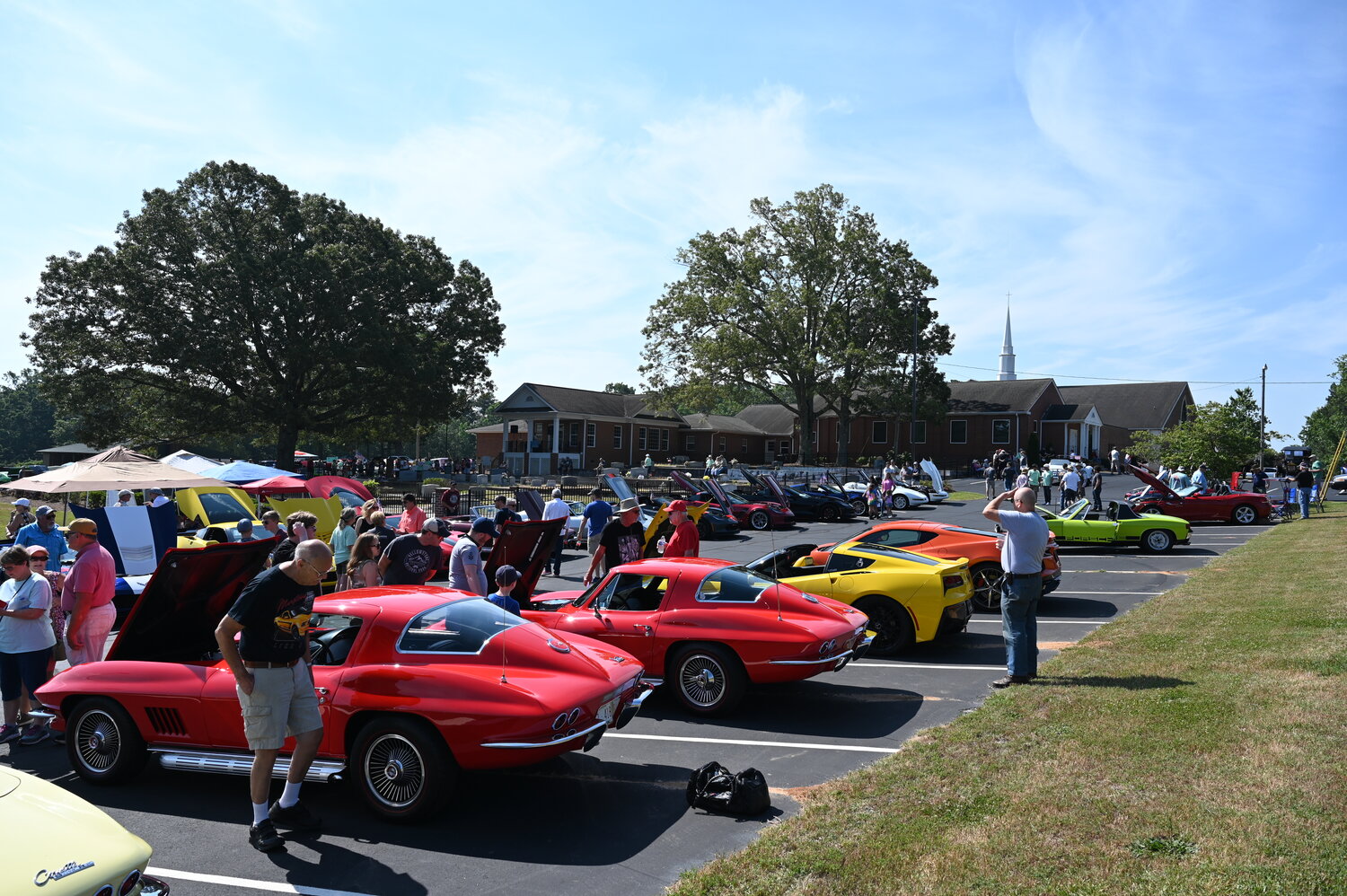 People stroll among cars on display at Flat Creek Baptist Church in Fayetteville on Saturday, June 3, 2023. (Index/Roger Alford).