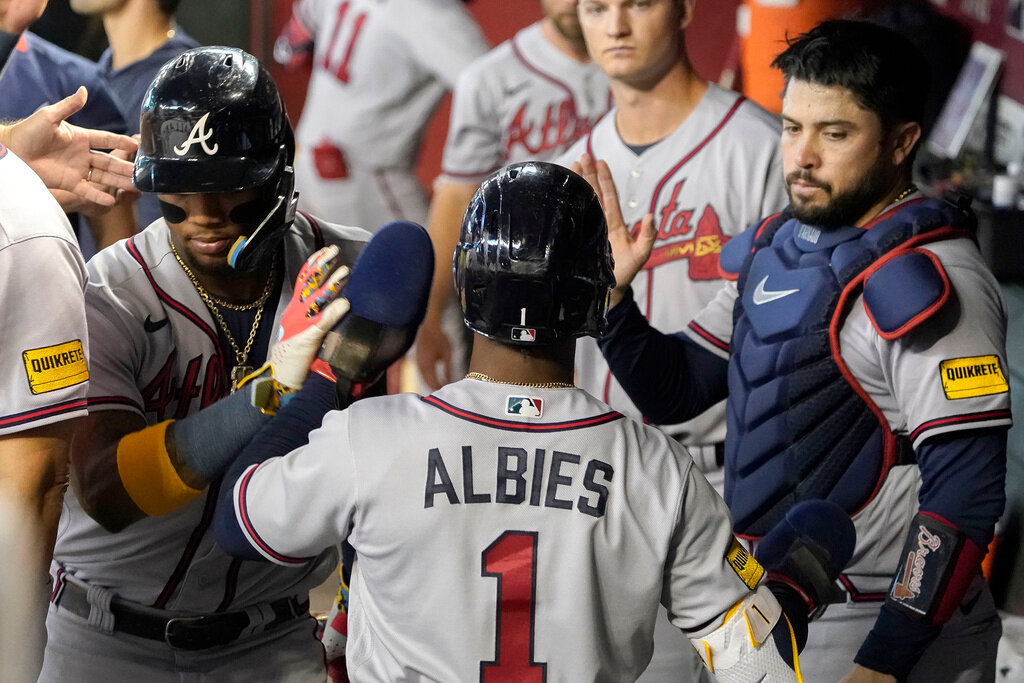 Atlanta Braves' Ozzie Albies is congratulated by teammates after scoring against the Arizona Diamondbacks in the second inning Sunday, June 4, 2023, in Phoenix. (AP Photo/Darryl Webb)