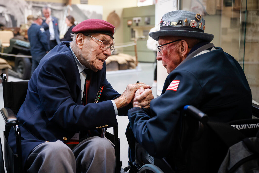 World War II veteran Britain's Bill Gladden, left, speaks with U.S WWII veteran Jack M. Larson in the Pegasus Bridge memorial in Benouville, Normandy, Monday, June 5, 2023. (AP Photo/Thomas Padilla)
