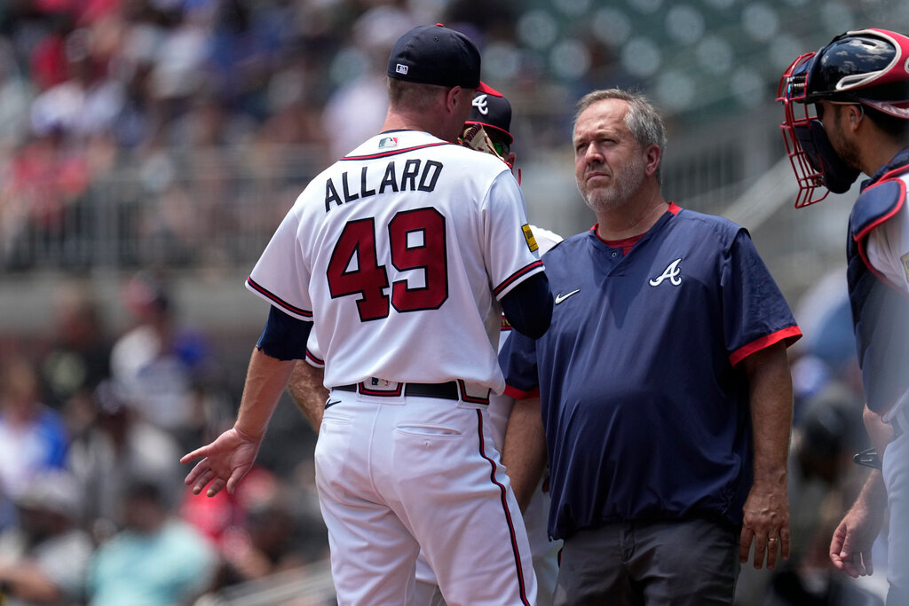 A member of Atlanta Braves training staff checks on pitcher Kolby Allard in the second inning against the Chicago White Sox Sunday, July 16, 2023, in Atlanta. Allard left the game. (AP Photo/John Bazemore)