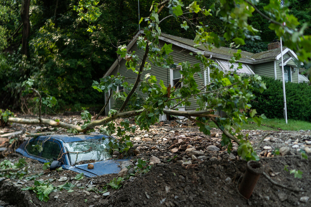 A car is buried in flood debris from recent storms and flooding on Monday, July 17, 2023, in Belvidere, New Jersey. (AP Photo/Eduardo Munoz Alvarez)