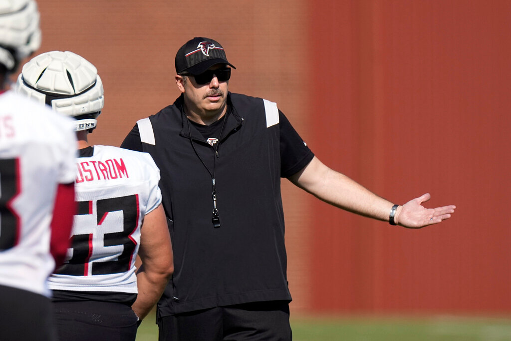 Atlanta Falcons head coach Arthur Smith talks with a few of his players during the first day training camp practice Wednesday, July 26, 2023, in Flowery Branch, Ga. (AP Photo/John Bazemore)