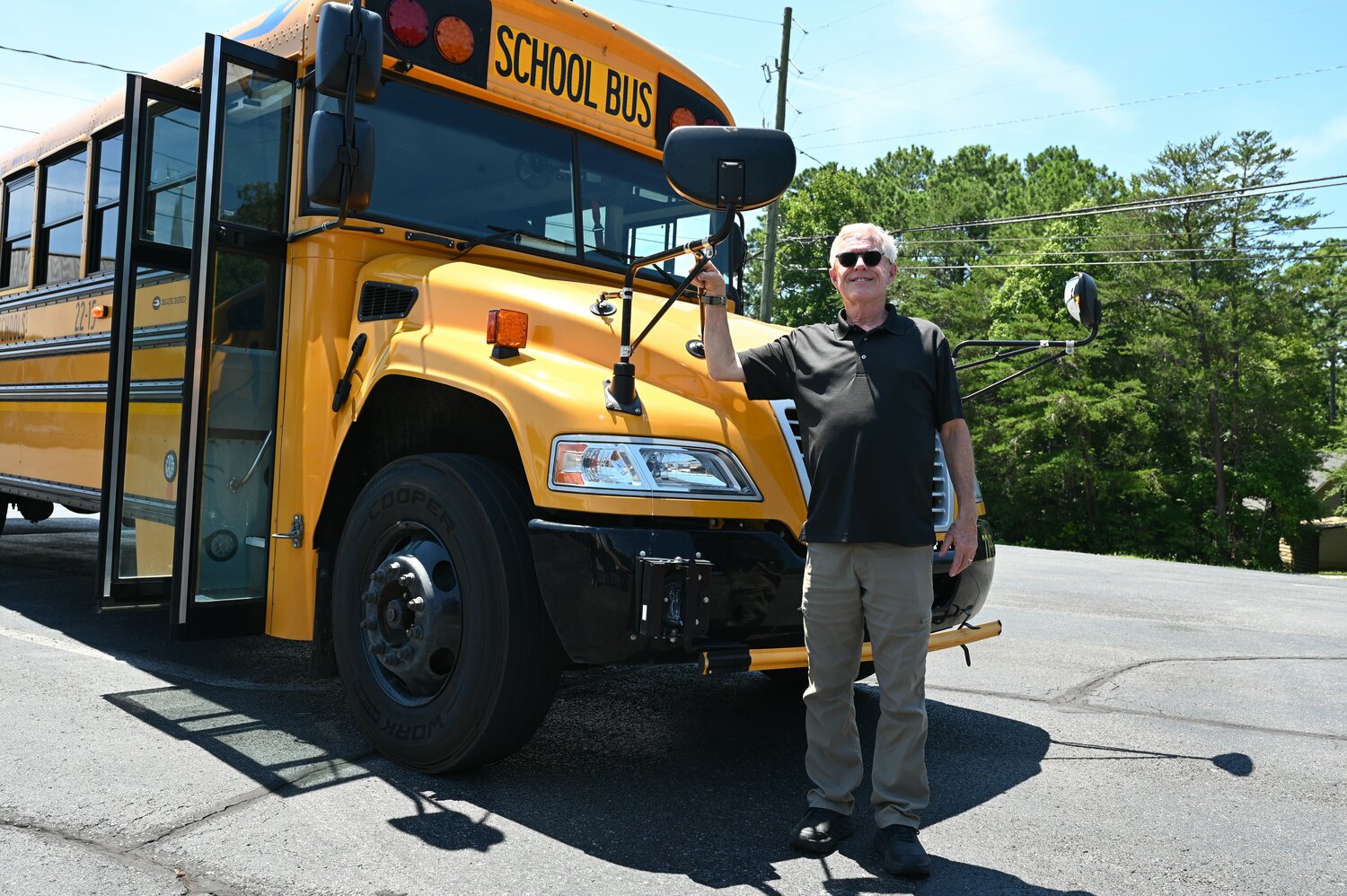 Holly Creek Baptist Church worship pastor Robert Richardson poses for a photo with the school bus he drives. (Index/Roger Alford)