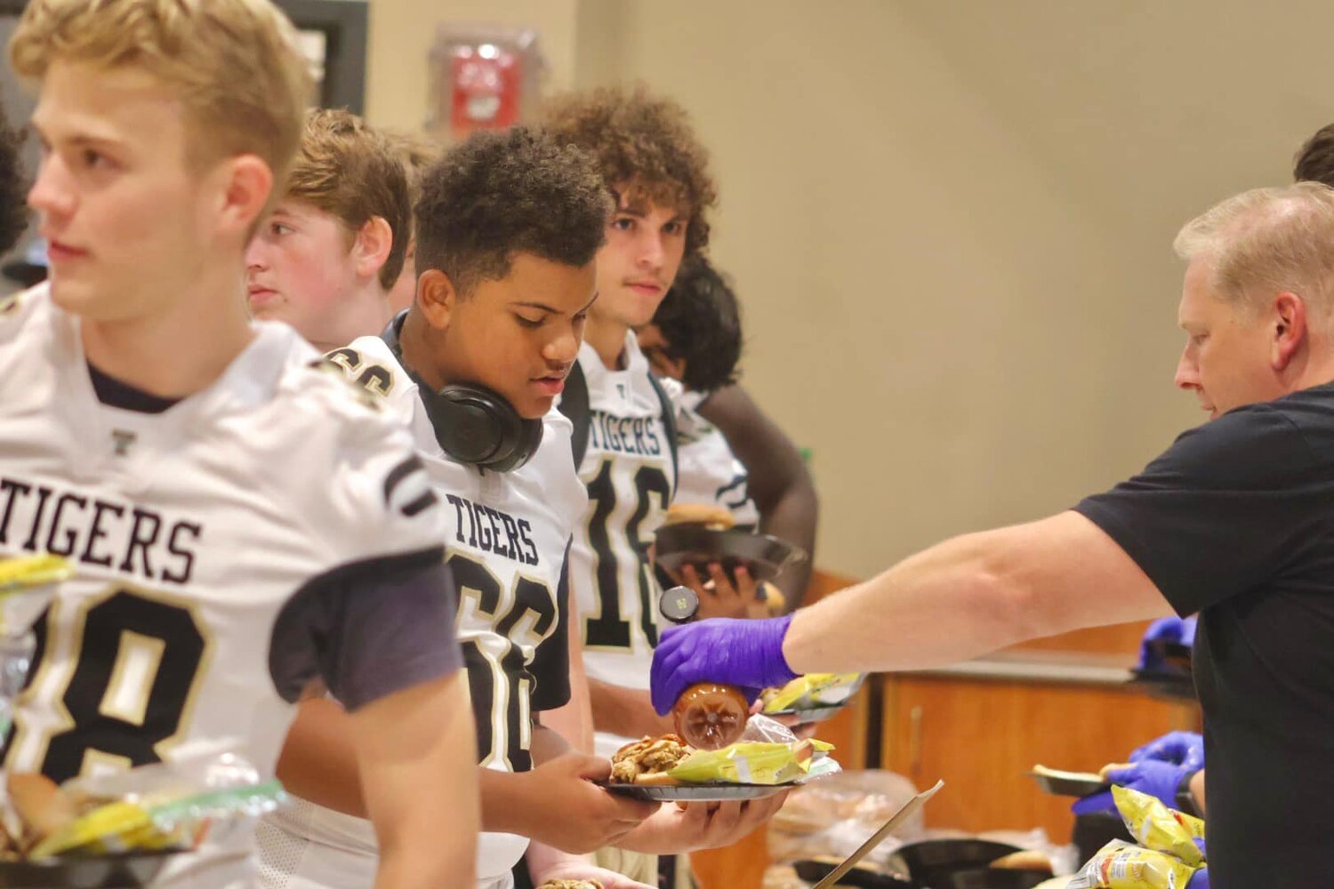 Servers dish up barbecue to football players at Gridiron Day in Carroll County, Ga.