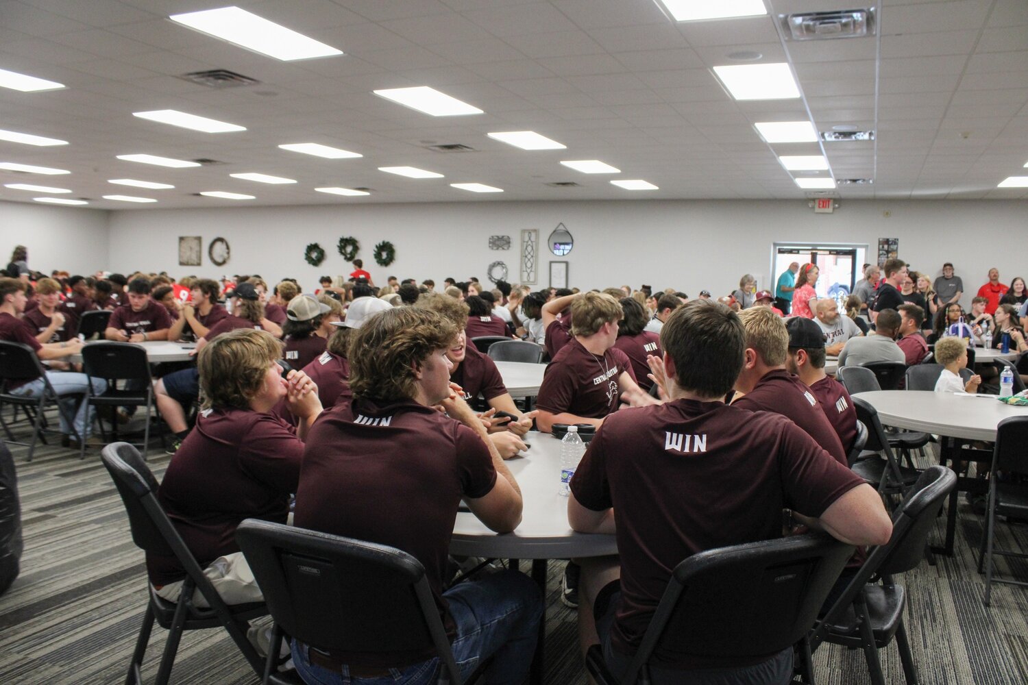 Football players eat together at Gridiron Day at Roopville Road Baptist Church on Thursday, Aug. 10, 2023.