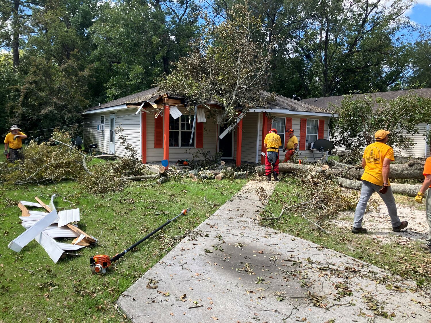 Volunteers from Georgia Baptist Disaster Relief remove trees form a damaged house in Valdosta on Monday, September 4, 2023.