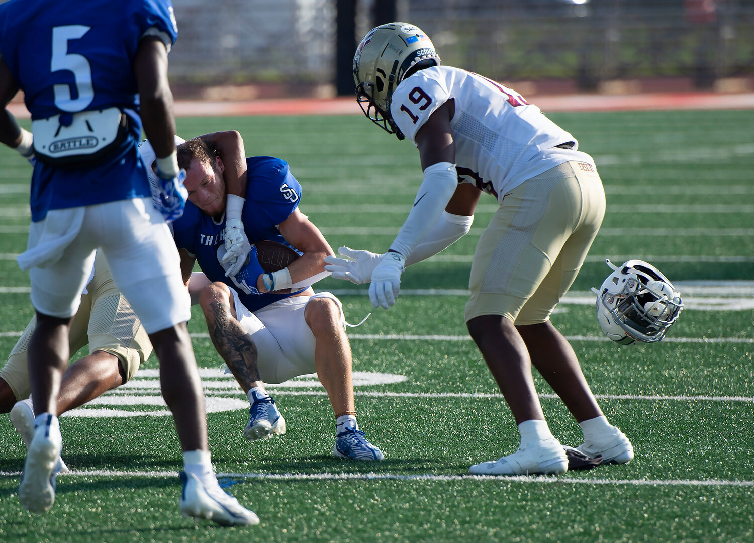Shorter University's Bo Mosteller loses his helmet as he is tackled by Erskine College's Donovan Bush, as Erskine's Johnmond Howard (19) looks on, during the fourth quarter Saturday, Sept. 9, 2023, in Rome, Ga. Shorter won 28-7. (Index/Henry Durand)